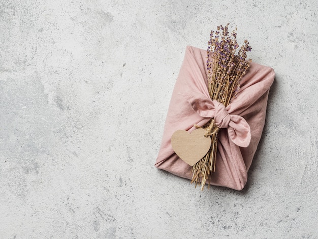 Keine Abfälle, umweltfreundliche Geschenkverpackung zum Valentinstag im Furoshiki-Stil mit trockenem Lavendel und leerem Bastellabel.