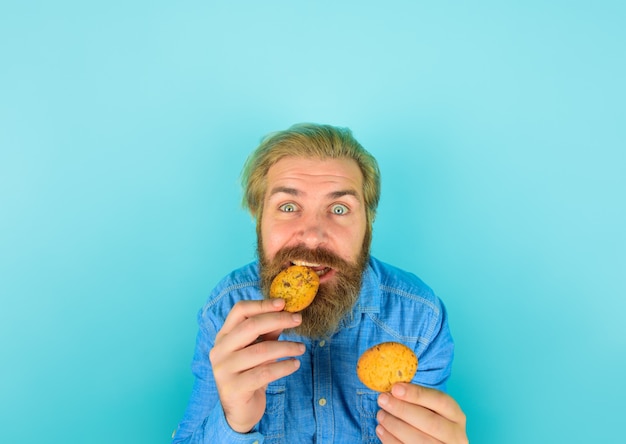 Foto kekse keks kekse süßer snack mann isst keks hausgemachte kekse bärtiger mann mit keksen