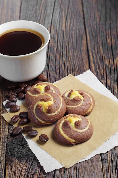 Kekse mit Schokolade und Tasse Kaffee auf altem Tisch