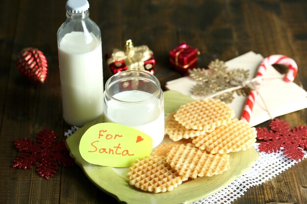 Kekse und Milch für den Weihnachtsmann. im Holzhintergrund