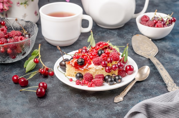 Kekskuchen mit Sommerbeeren auf einem schwarzen Hintergrund