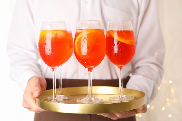 Kellner, der Tablett mit Aperol-Spritz-Cocktail hält