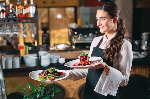 Foto kellner im dienst im restaurant. der kellner trägt geschirr