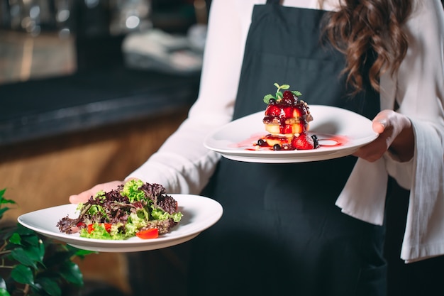 Kellner im Dienst im Restaurant. Der Kellner trägt Geschirr