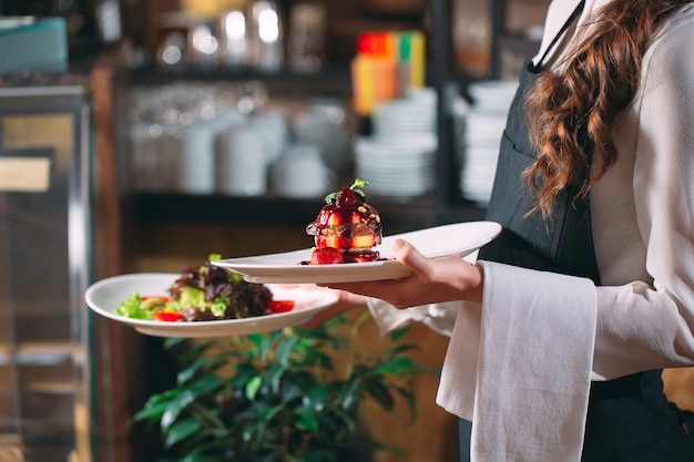 Kellner im dienst im restaurant. der kellner trägt geschirr