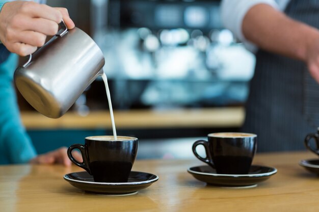 Kellner macht Tasse Kaffee an der Theke im Café