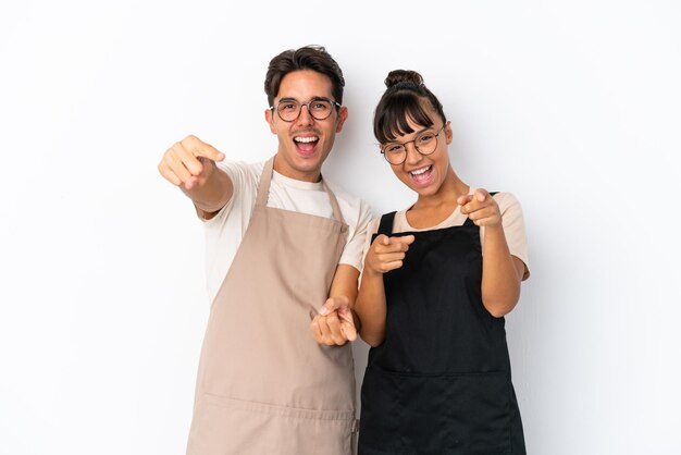 Kellner mit gemischten Rassen im Restaurant, die auf weißem Hintergrund isoliert sind, zeigen mit dem Finger auf Sie, während sie lächeln