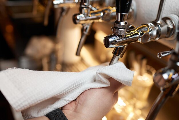 Foto kellner oder barkeeper reinigen bierhähne an der theke in kneipe und restaurant