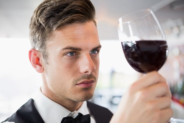 Foto kellner schaut auf ein glas wein