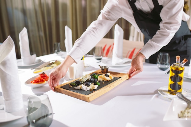 Kellner Serviertisch im Restaurant bereitet sich auf den Empfang der Gäste vor.