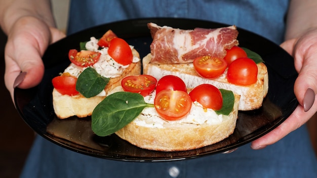 Kellnerin, die ein hölzernes Tablett mit Bruschetta in ihrer Hand hält