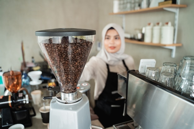 Kellnerin hält eine Kaffeemühle