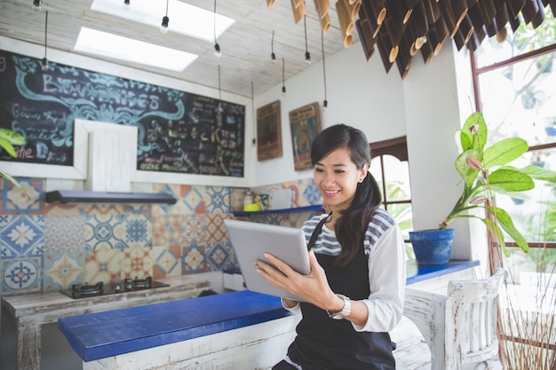 Kellnerin mit digitalem Tablet im Café