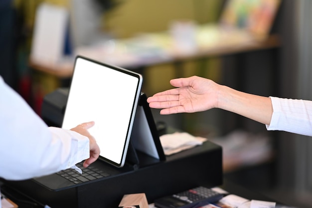 Kellnerin mit Tablet, um Bestellungen von Kunden am Schalterservice im Café zu erhalten.