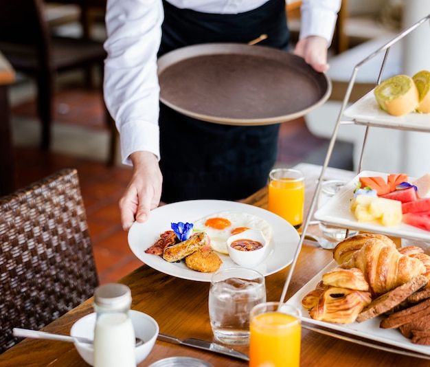 Kellnerin serviert Frühstück in einem Restaurant