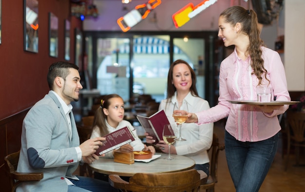 Kellnerin und Familie im Café