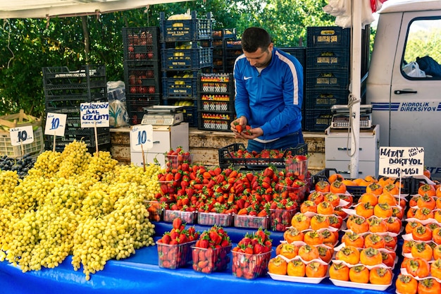 Kemer, Turquía - 8 de noviembre de 2021: comerciante de frutas en un bazar local