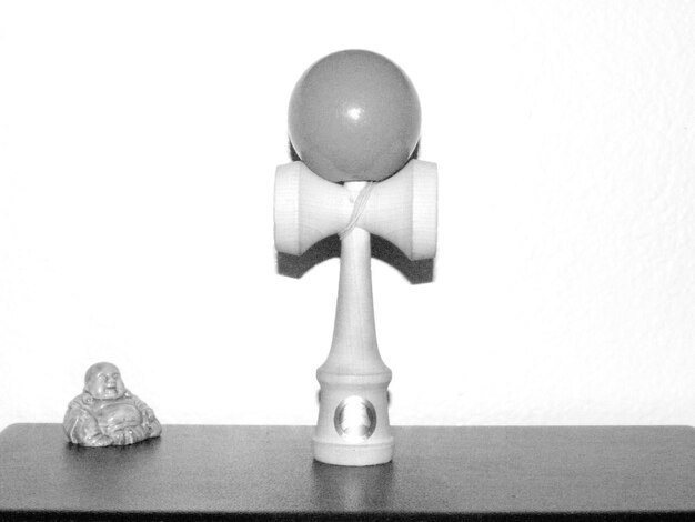 Foto kendama na mesa contra a parede branca