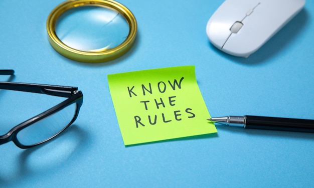 Kennen Sie die Regeln auf Haftnotizen mit Geschäftsobjekten auf blauem Hintergrund
