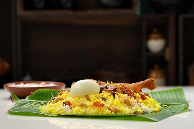 Kerala Chicken dum biryani arreglado tradicionalmente en una hoja de plátano y raita