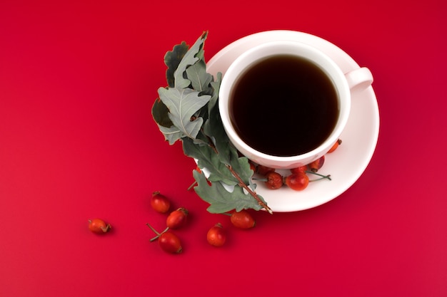 Keramikbecher mit heißem Kaffee und Hagebutten