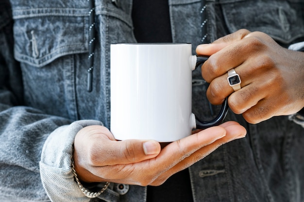 Keramikbechermodell Nahaufnahme Afroamerikaner in einer Jeansjacke mit weißer Tasse mit schwarzem Griff von