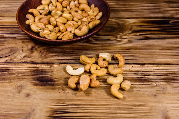 Keramikplatte mit gerösteten Cashewnüssen auf einem Holztisch