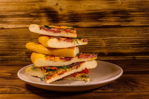 Keramikplatte mit geschnittener hausgemachter Pizza auf einem Holztisch