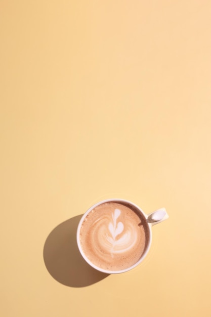 Keramiktasse Kaffee mit einem Herzmuster mit hartem Schatten Minimalistische monochrome Kaffeekunst Draufsicht