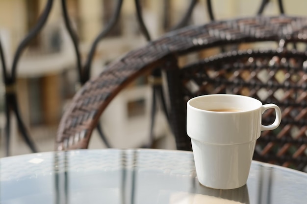 Keramiktasse mit aromatischem Kaffee auf Glastisch im Freien Platz für Text Guten Morgen