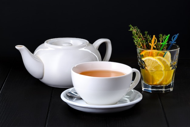 Keramische Teekanne und Tasse mit Echinocea-Tee auf dunklem Hintergrund