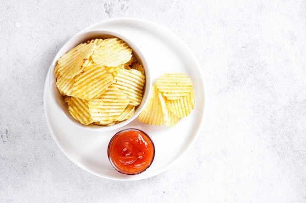 Keripik Kentang oder knusprige Kartoffelchips in einer Tellersoße