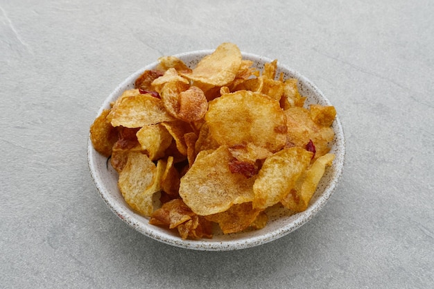 Keripik Singkong Balado Balado Spicy Chips Cassava Cracker auf grauem Hintergrund auf Teller serviert