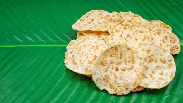 Foto keripik tempe o tempe chips en hoja de plátano, una comida típica indonesia hecha de tempeh en rodajas finas y luego frita con harina sazonada