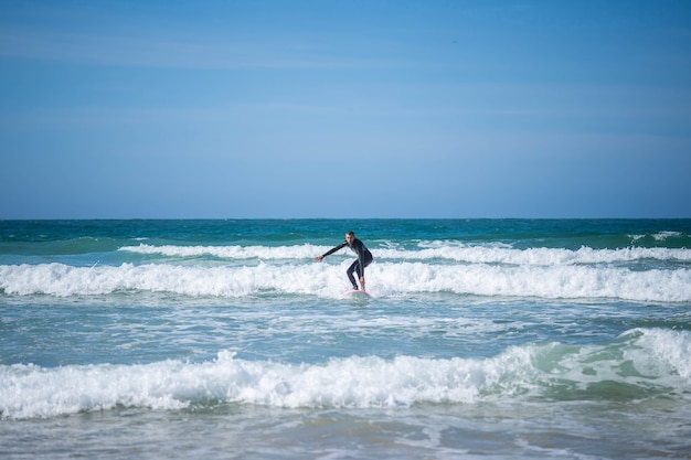 Kerl auf einem Surfbrett auf angewinkelten Beinen. Konzept: Gleichgewicht, Stabilität, Koordination