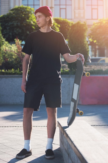 Kerl, der Skateboard hält.