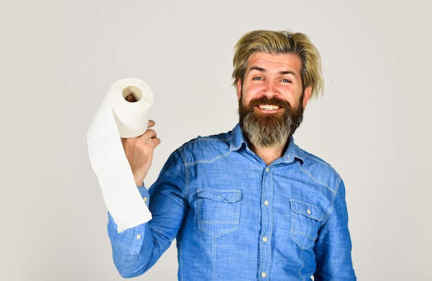 Kerl, der Spaß mit Toilettenpapier hat. Weichheitsstärke und Saugfähigkeit. Verhindern Sie das Horten von Toilettenpapier. Mann hält Toilettenpapier. Hipster mit Gewebe. Nutzung einschränken. Online Shop. Kaufen Sie wichtige Güter.
