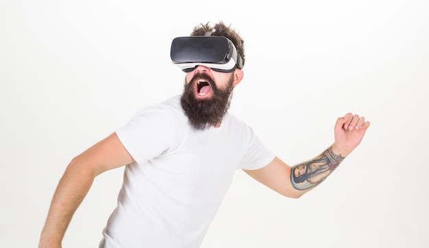 Kerl mit kopfmontiertem Display interagiert mit virtueller Realität. Virtuelle Aktivität. Hipster spielen virtuelles Sportspiel. Mann bärtiger Gamer VR-Brille weißer Hintergrund. Virtual-Reality-Spielkonzept. Cyber-Sport.