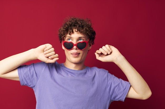 Kerl mit roter lockiger Haarsommerartmode-Sonnenbrille lokalisierte Hintergrund