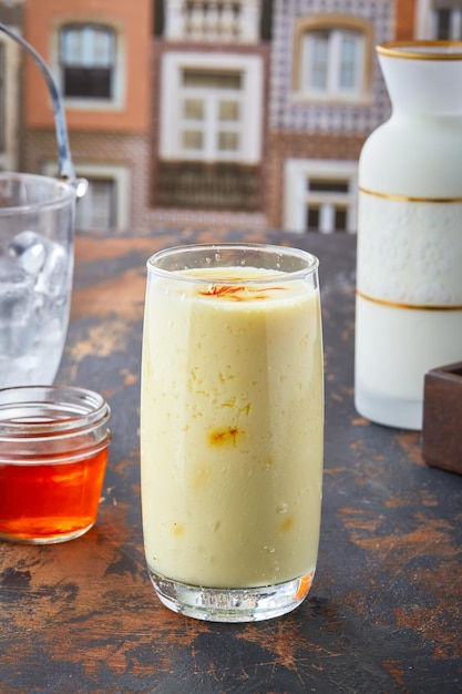 Kesar Saffron Lassi mit Honig, serviert im Glas isoliert auf Tischplatte mit Blick auf die Punjabi-Kultur