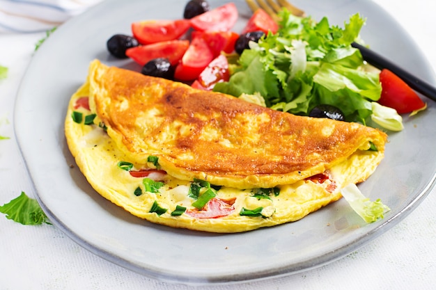 Keto-Frühstück. Omelett mit Käse, Tomaten und Frühlingszwiebeln auf Leuchttisch. Italienische Frittata. Keto, ketogenes Mittagessen.