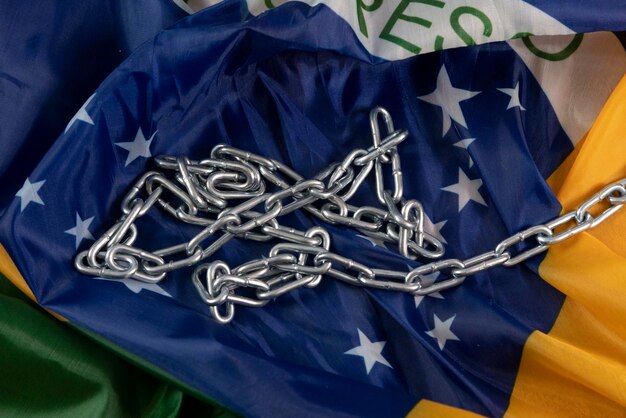 Foto kette und brasilianische flagge symbolisieren die sklaverei im land