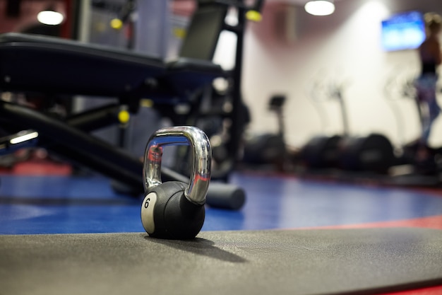 Kettlebell na academia ao lado de equipamentos esportivos