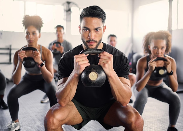 Kettlebell-Workout und Fitness-Kurs mit einem Fitnesstrainer und Personen, die mit Cardio und Bewegung trainieren Porträt eines starken Personal Trainers und Sportfreunden in einem Wellness-Fitnessclub mit Motivation