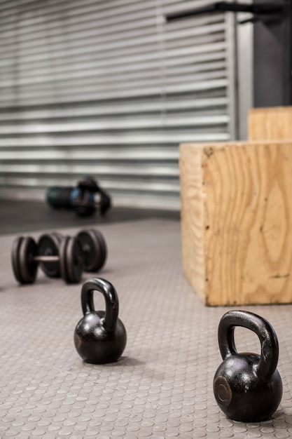 Foto kettlebells y pesas en el suelo de un gimnasio