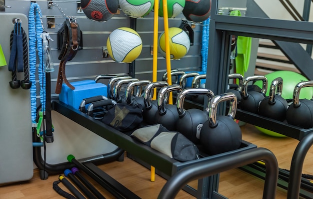 Kettlebells en un rack y equipamiento deportivo para entrenar en el gimnasio