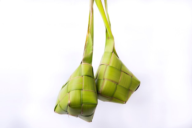 Ketupat (bolinho de arroz) é um alimento tradicional da Indonésia durante o Eid Mubarak isolado sobre uma superfície branca