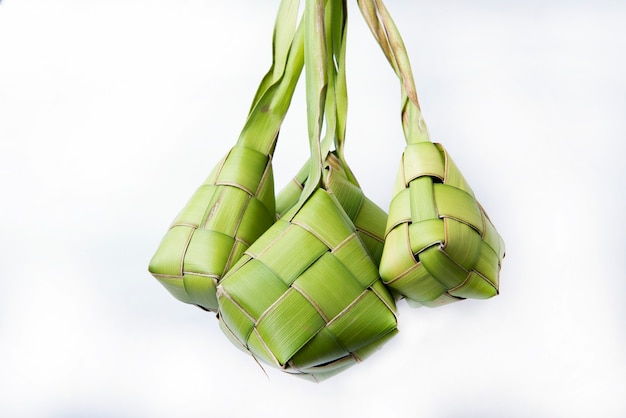 Ketupat (bolinho de arroz) é um alimento tradicional da Indonésia durante o Eid Mubarak isolado sobre uma superfície branca