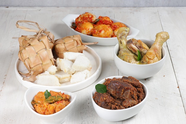 Ketupat Lebaran servido con sambal goreng opor ayam sayur labu siam rendang y telur balado