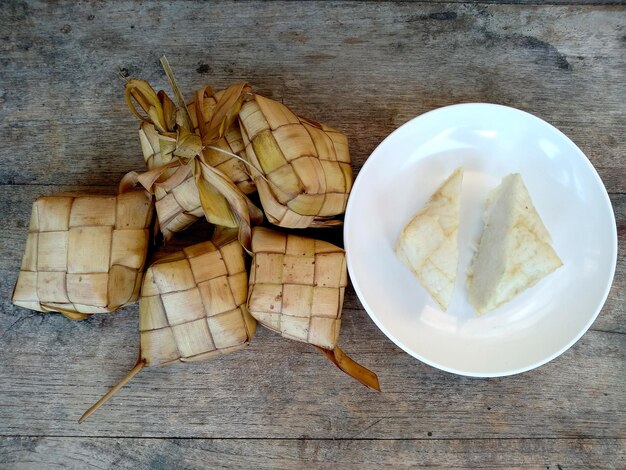 Ketupat oder Reisknödel auf Holzhintergrund Indonesische kulinarische Küche